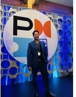 Kristian Bainey photographed in front of a Project Management Institute media wall