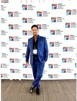 Kristian Bainey photographed at a corporate event in front of a media wall